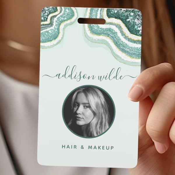 A Teal And Gold Agate-Patterned Id Badge With Addison Wilde'S Name, A Black And White Headshot, And Hair &Amp; Makeup Below.