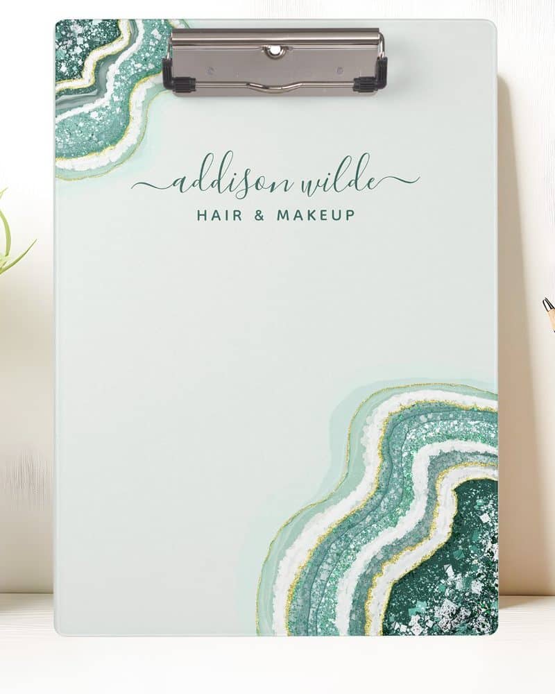 A light green clipboard with an agate design and Addison Wilde Hair & Makeup printed on it.