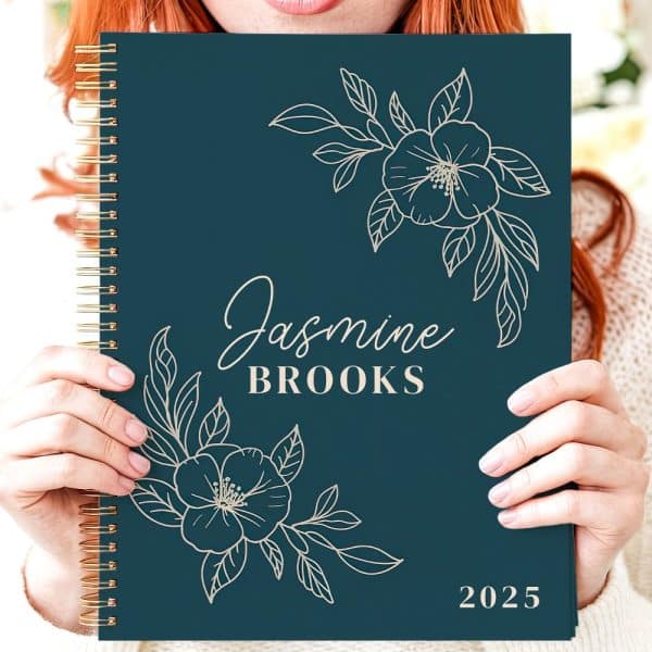 Teal 2025 Planner With Gold Spiral Binding, Floral Design, And The Name Jasmine Brooks.