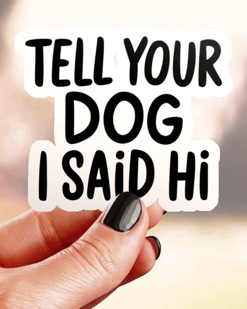 Hand holding a sticker that says Tell Your Dog I Said Hi.