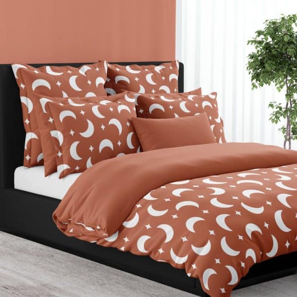 A Rust-Colored Duvet Cover And Pillow Shams Featuring A White Crescent Moon And Star Pattern.