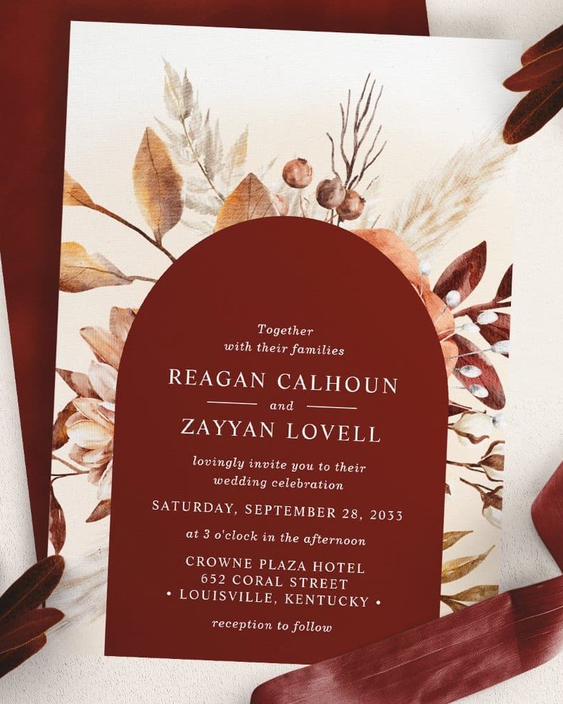 Wedding invitation with autumnal floral design; names Reagan Calhoun and Zayyan Lovell.