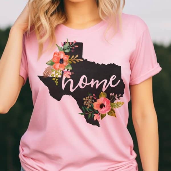 Pink T-Shirt With A Floral Design In The Shape Of Texas And The Word Home.