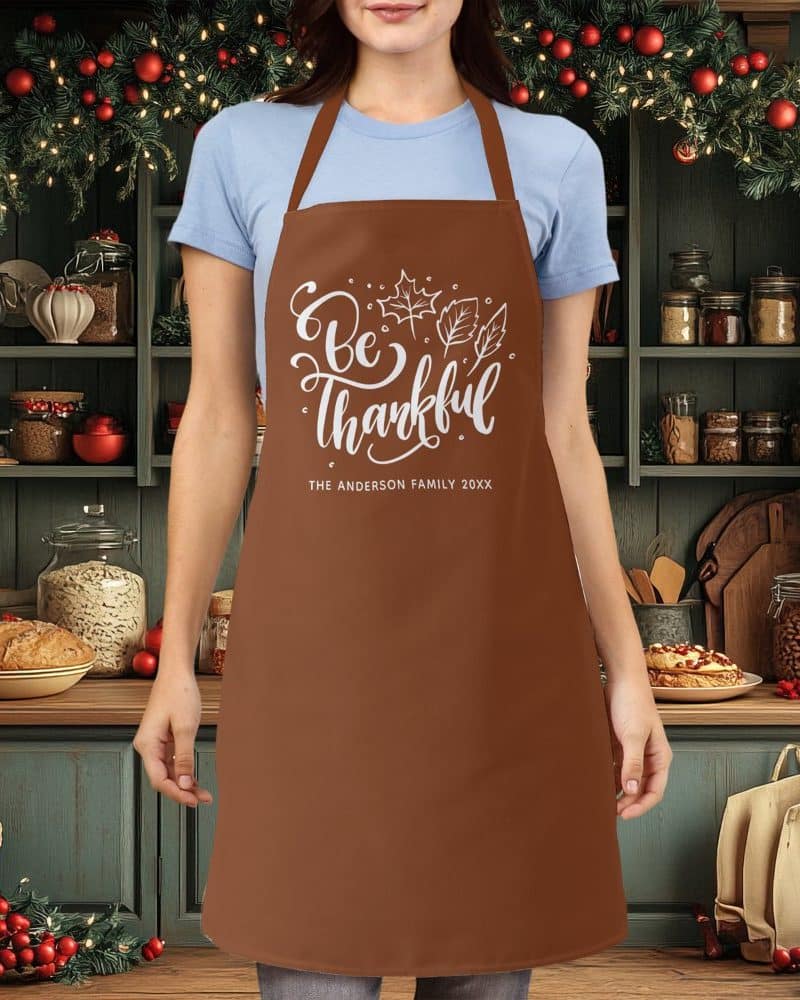 Brown apron with the words Be Thankful and autumn leaves, personalized with a family name.