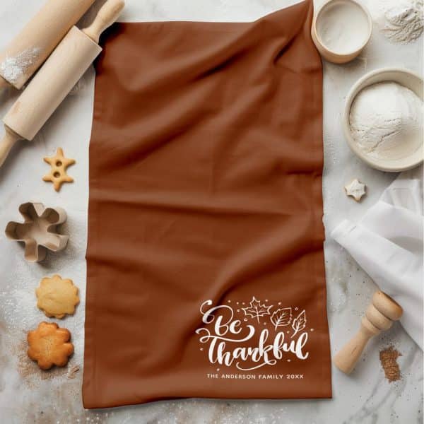 Brown Kitchen Towel With The Text Be Thankful And Autumn Leaves, Personalized With A Family Name And Year.