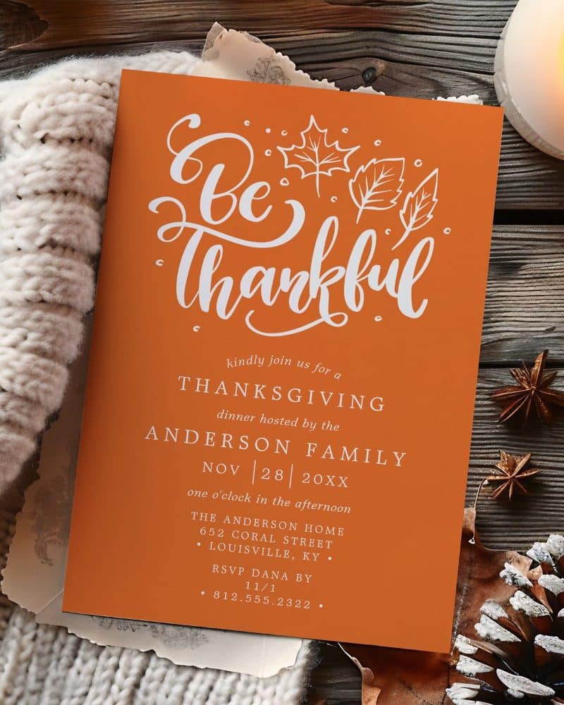 An orange Thanksgiving invitation with white script that says Be Thankful. The invitation includes date, time, location, and RSVP information.