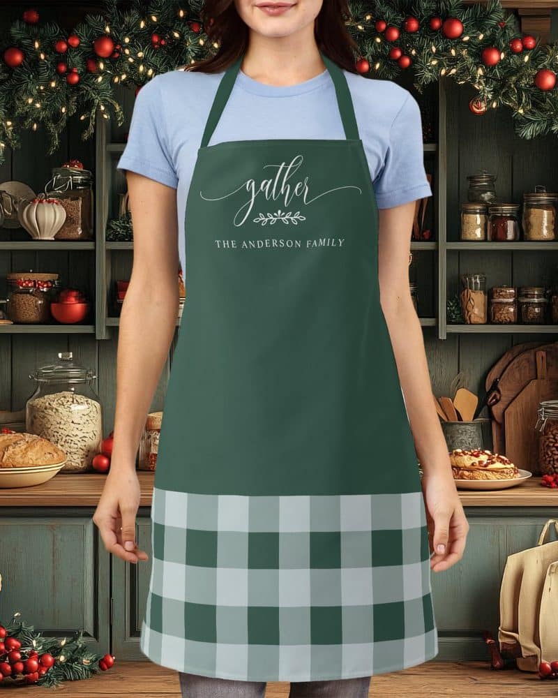 Green apron with a buffalo plaid bottom and the words Gather, The Anderson Family on the top.