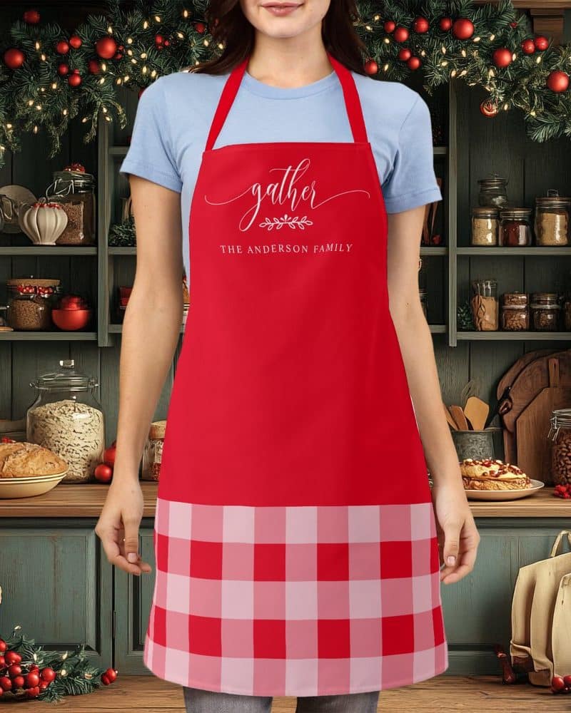 Red apron with a buffalo plaid bottom and the words Gather, The Anderson Family in a script font.