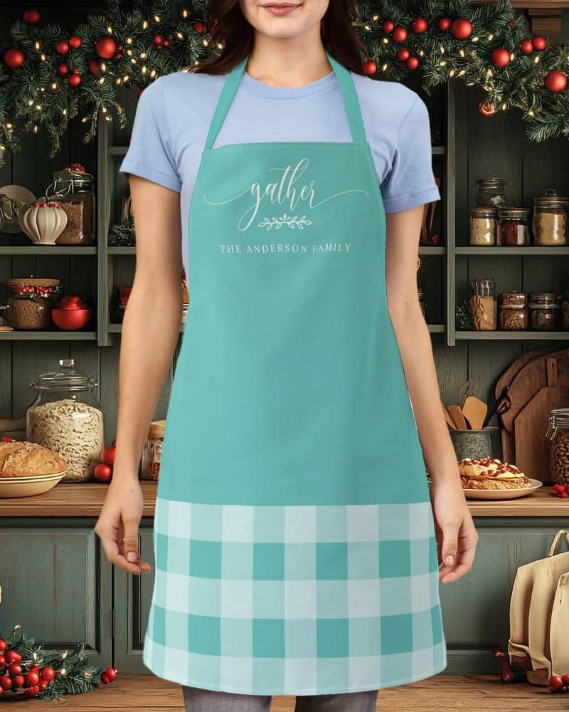Teal apron with a white gingham bottom, personalized with the words Gather and The Anderson Family.