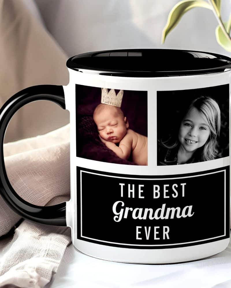 A white coffee mug with a black handle and interior features photos of a baby and a young girl, along with the text The Best Grandma Ever.