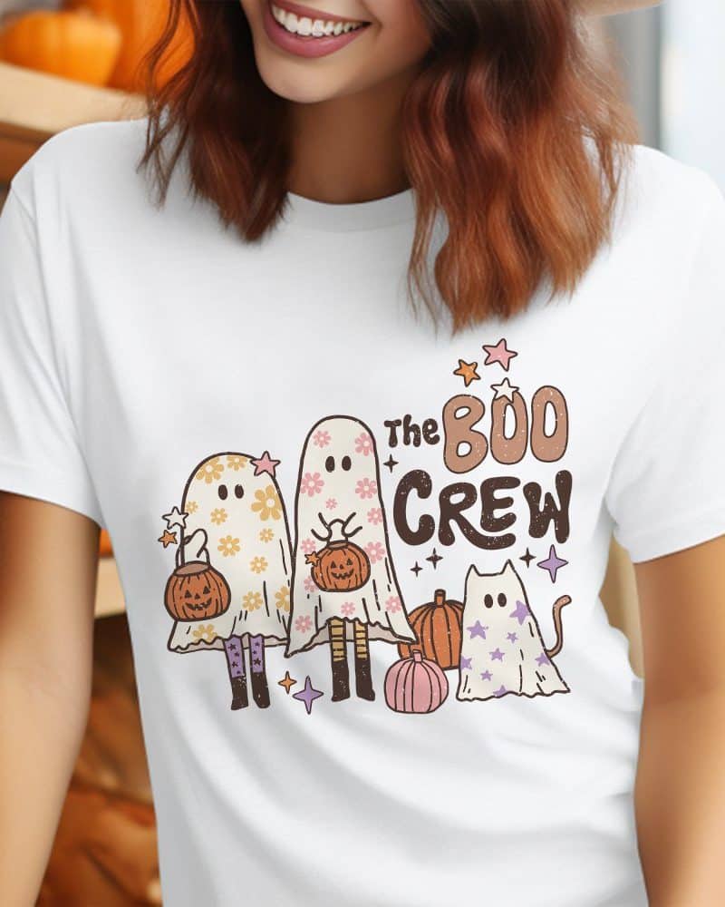 White t-shirt featuring a Halloween design of two ghosts carrying pumpkins and a cat ghost.