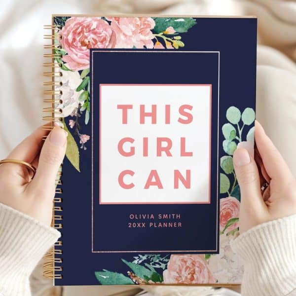 A Navy Planner With Pink Floral Accents And The Text This Girl Can.
