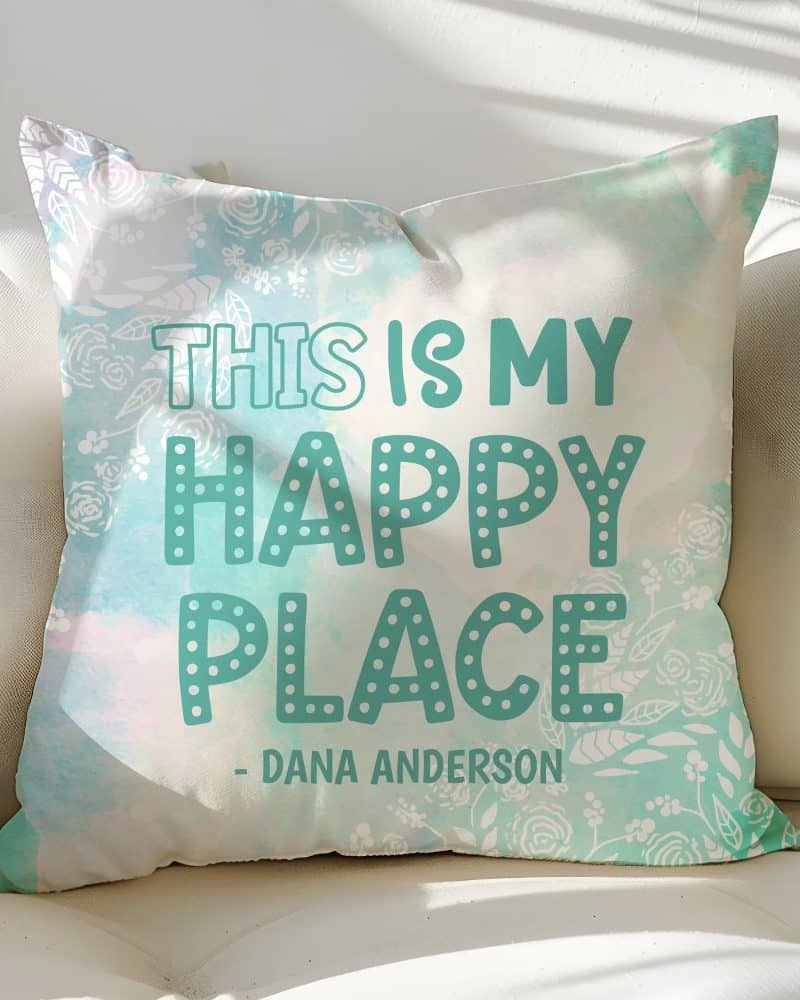 Teal decorative pillow with the text This is my Happy Place and the designer's name.