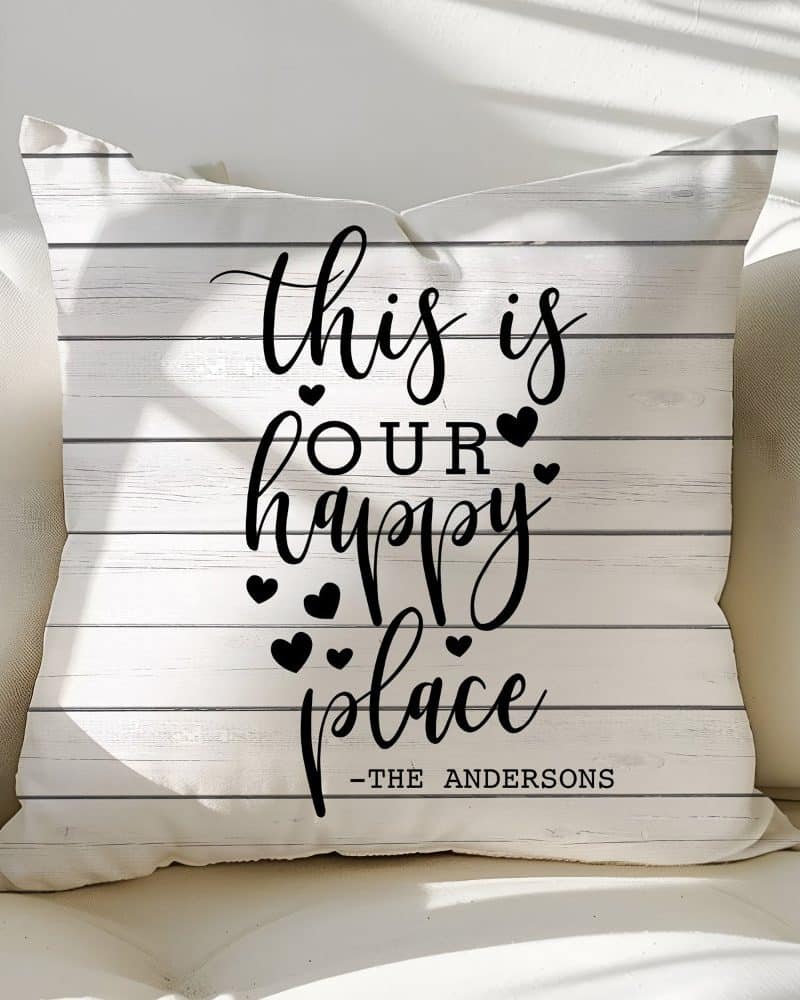White pillow with black text reading This is our happy place, and The Andersons.