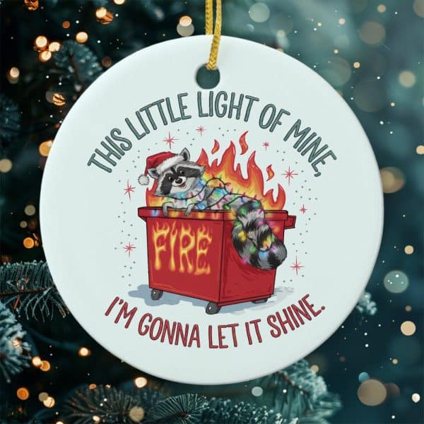 Christmas Ornament Featuring A Raccoon Wearing A Santa Hat, Inside A Flaming Dumpster Decorated With Christmas Lights. The Text Reads, This Little Light Of Mine, I'M Gonna Let It Shine.