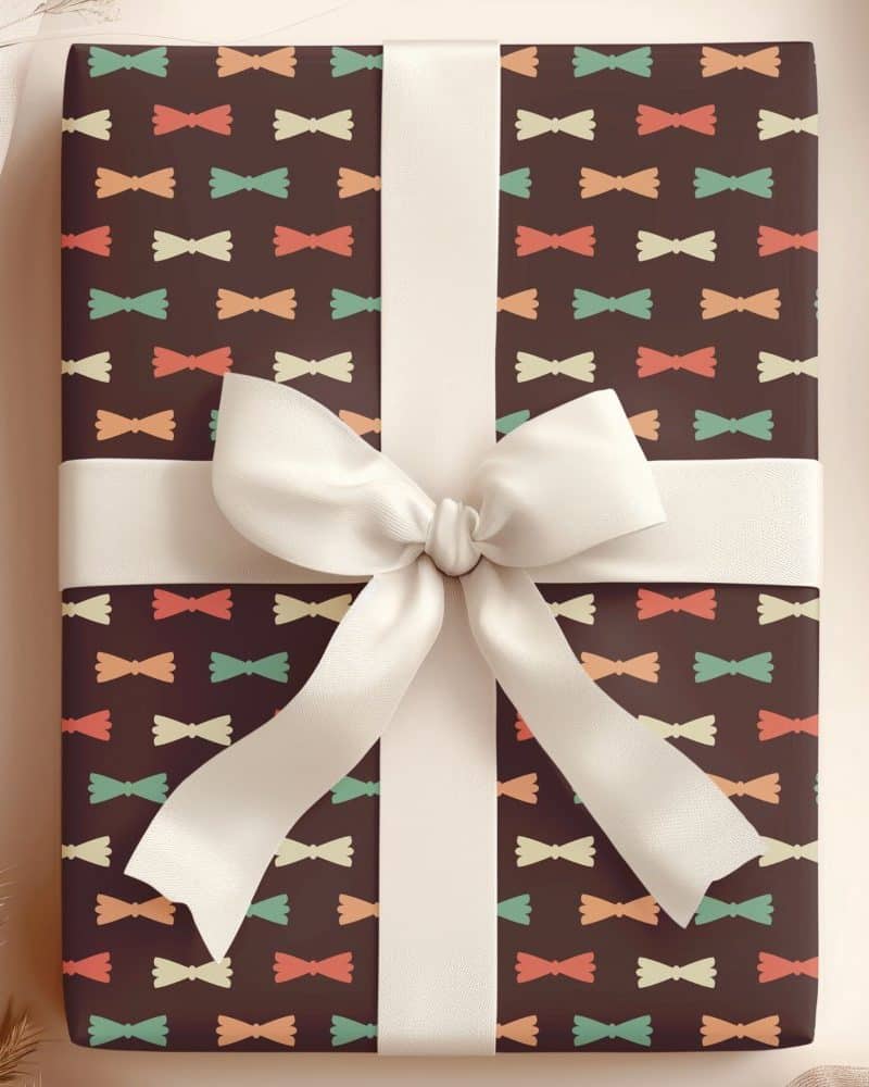 A gift wrapped in brown paper with a repeating pattern of colorful bowties and tied with a white ribbon.