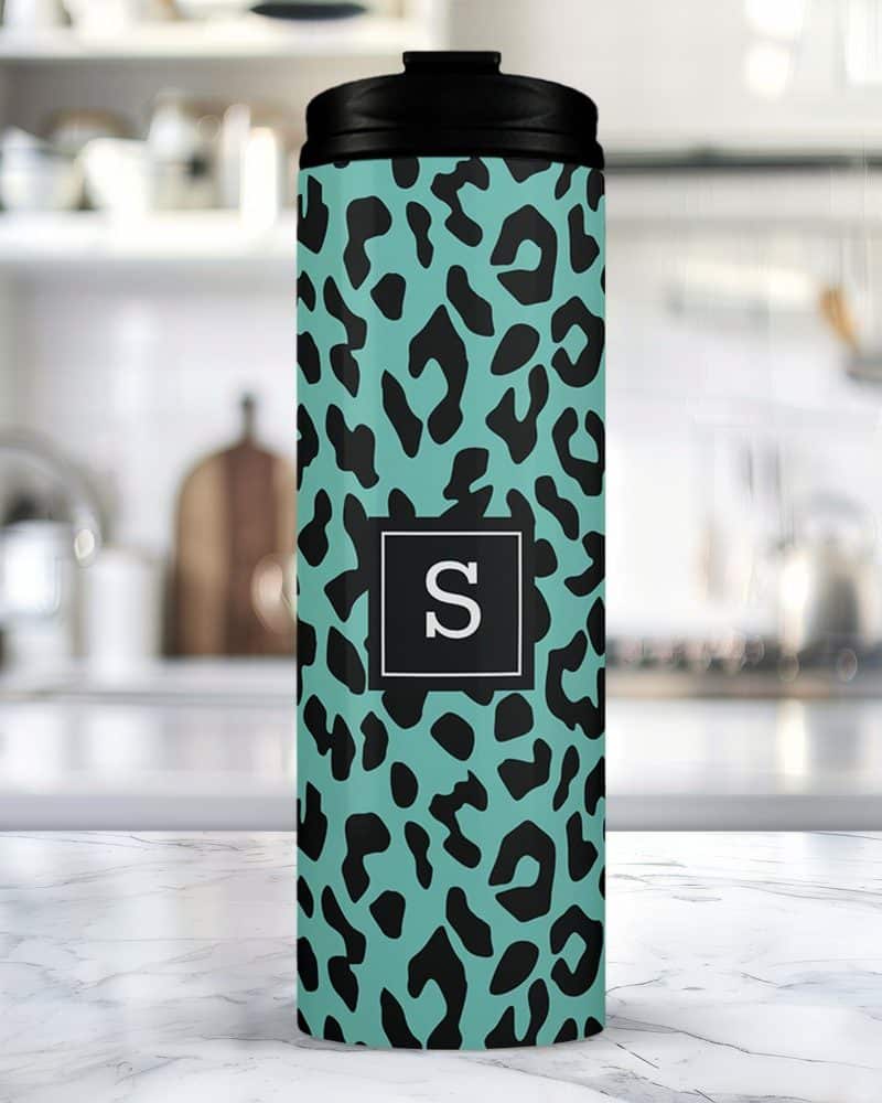 Teal travel tumbler with a black leopard print and a black square featuring the letter S.