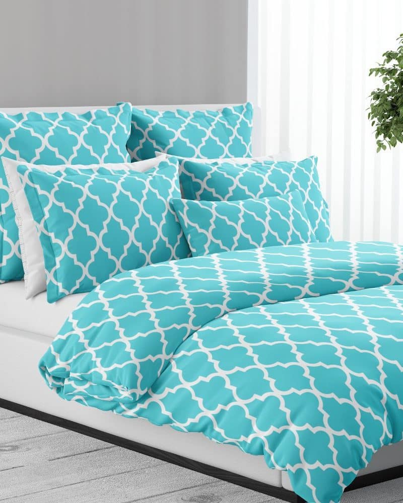 Teal duvet cover and pillow shams with a white quatrefoil pattern.