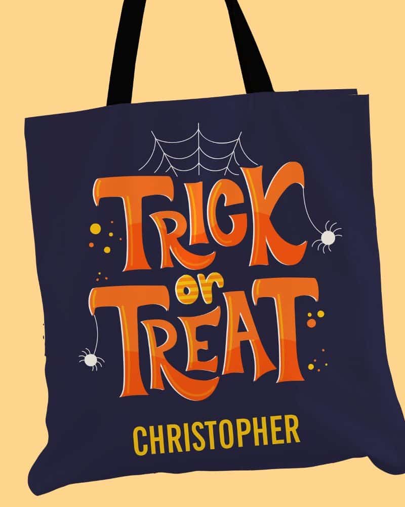 Dark blue Halloween tote bag with orange Trick or Treat lettering, spiders, and a personalized name, Christopher.