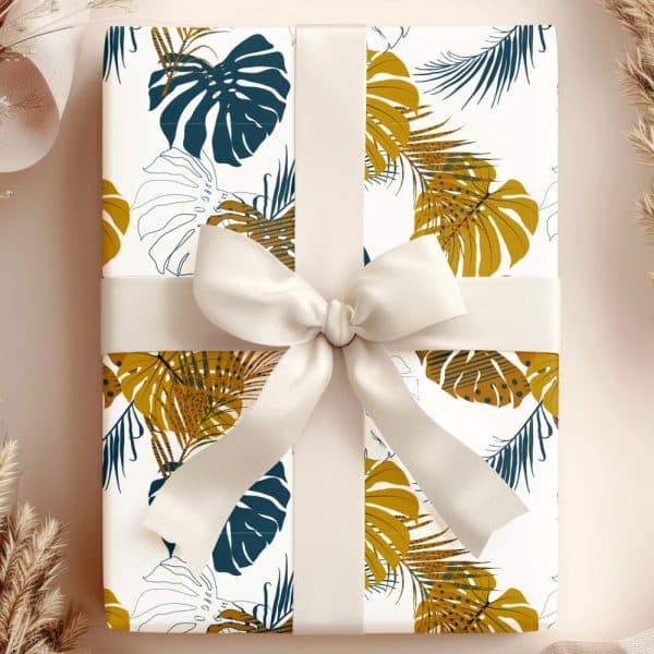 A Gift Wrapped In White Paper With A Tropical Leaf Pattern In Gold And Teal, Tied With A Cream-Colored Ribbon.