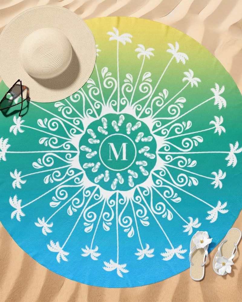 Round beach towel with a teal and yellow ombre design, featuring a central mandala design with palm trees and flip flops surrounding a monogrammed M.
