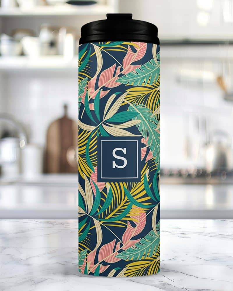 A tropical leaf patterned travel tumbler with a monogrammed initial S.