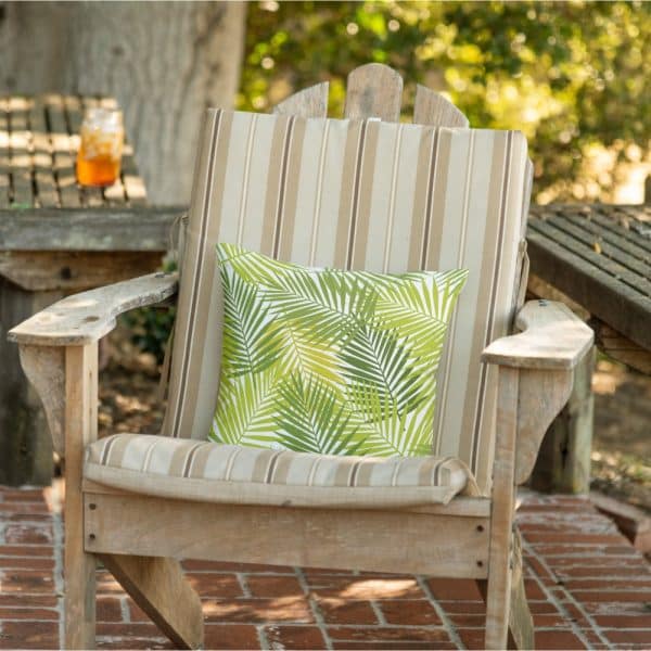 A Green Palm Leaf Patterned Throw Pillow Sits On A Wooden Chair.