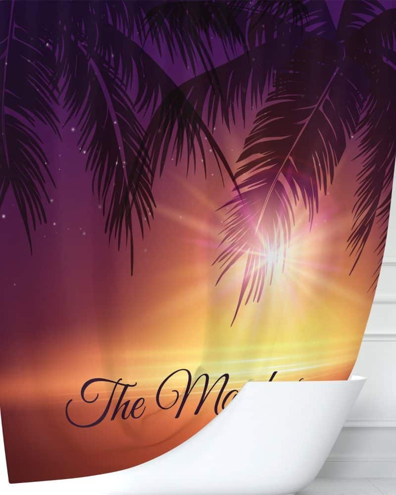 Shower curtain depicting a sunset beach scene with palm trees silhouetted against a vibrant sky.