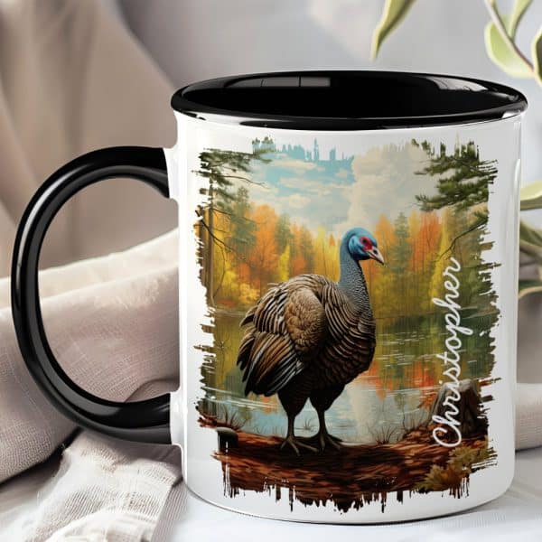 Black-Handled Mug With A Painting Of A Wild Turkey Standing By A Lake In An Autumn Forest.