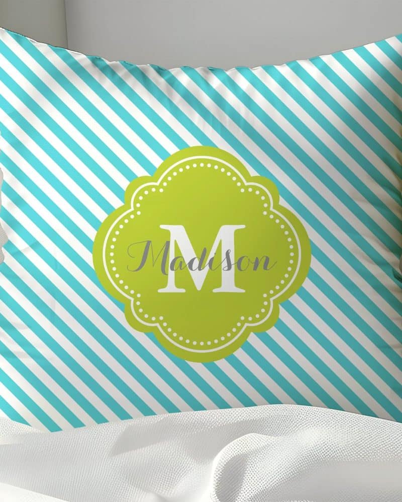 Teal and white striped pillow with a lime green monogram of the letter M and the name Madison.