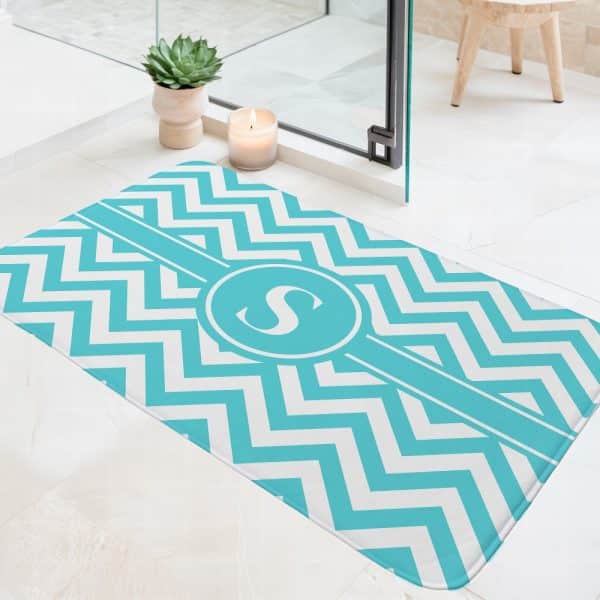 Teal And White Chevron Patterned Bath Mat With A Monogrammed S In A Circle.