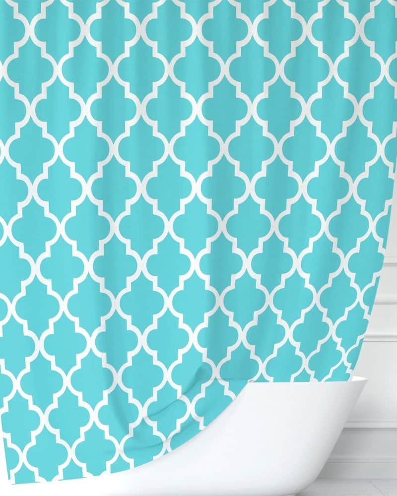 Teal shower curtain with a white quatrefoil pattern.