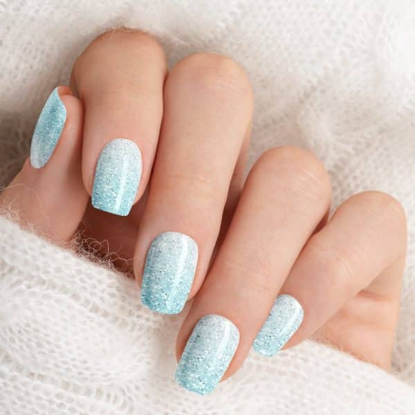 Closeup Of A Hand With Light Blue Glitter Ombre Nail Polish.