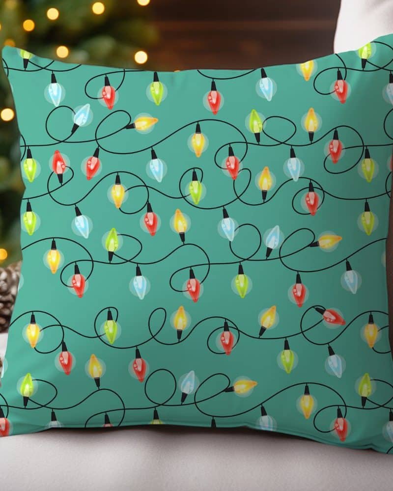 Teal throw pillow with a pattern of colorful Christmas lights.