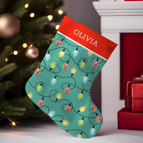 Teal Christmas Stocking With A Red Cuff, Personalized With The Name Olivia, And Decorated With A Pattern Of Colorful String Lights.