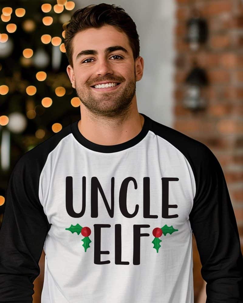 Man wearing a white and black baseball-style long-sleeved shirt that says Uncle Elf.