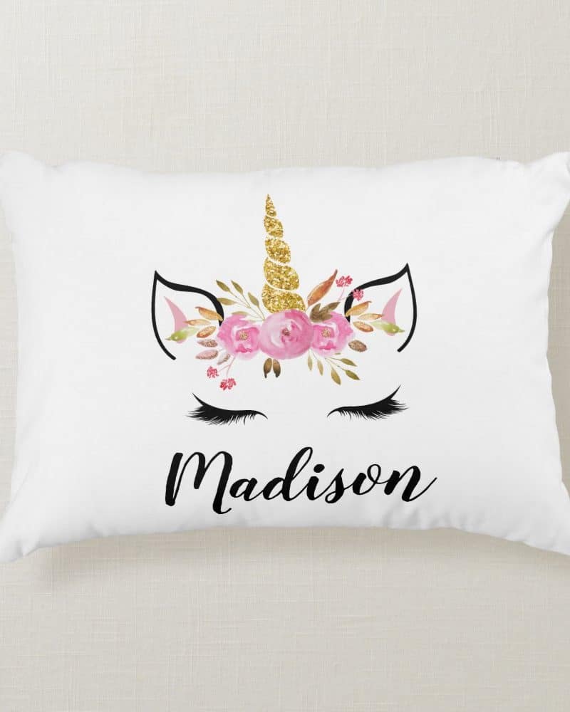 White pillow with a floral unicorn design and the name Madison.