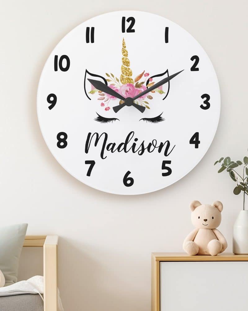 White round clock with a unicorn face and the name Madison.