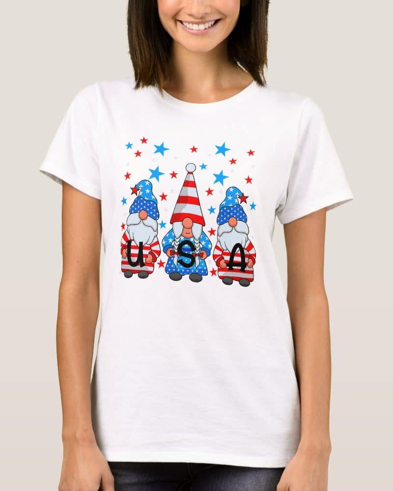 Woman wearing a white t-shirt featuring three gnomes in patriotic attire spelling USA.