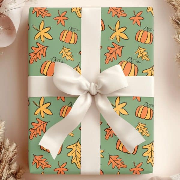 Autumn-Themed Gift Box With A Cream-Colored Ribbon. The Box Is Wrapped In Green Paper With A Repeating Pattern Of Pumpkins And Leaves.