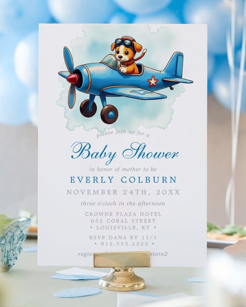 Baby shower invitation featuring a cartoon puppy piloting a blue airplane.