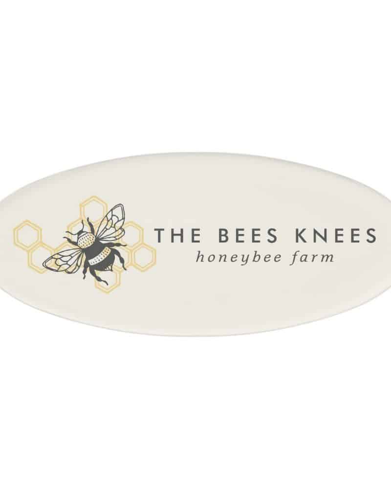 Oval logo for The Bees Knees honeybee farm featuring a stylized bee illustration in a honeycomb.