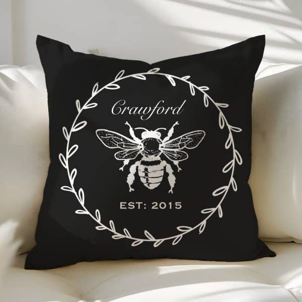 Black Pillow With A White Bee Illustration In A Wreath Design, The Name Crawford And The Year 2015.