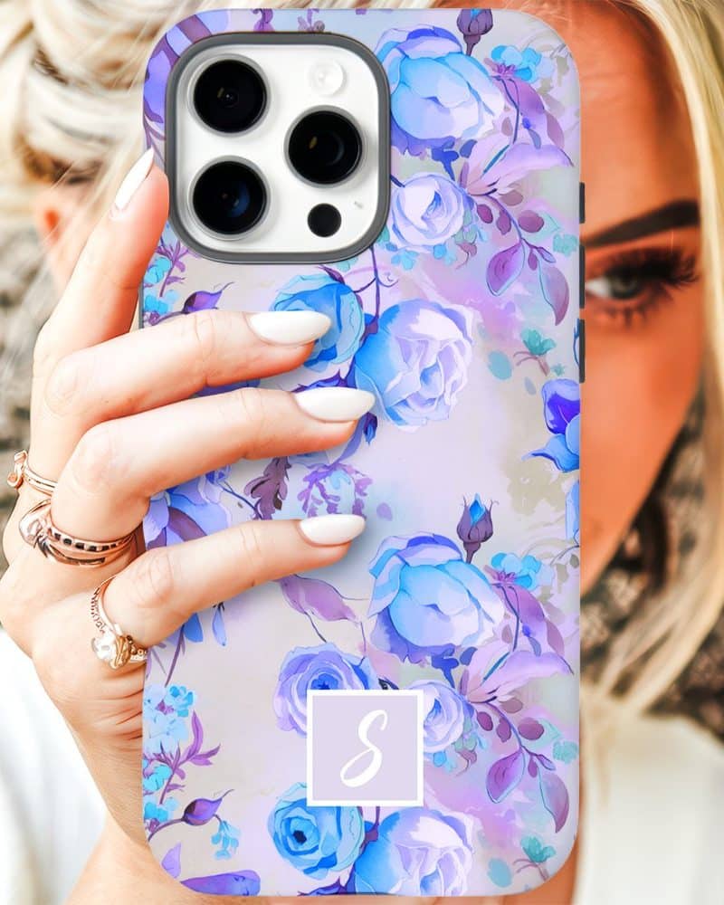 A woman's hand holding an iPhone case featuring a watercolor floral design in shades of purple and blue.
