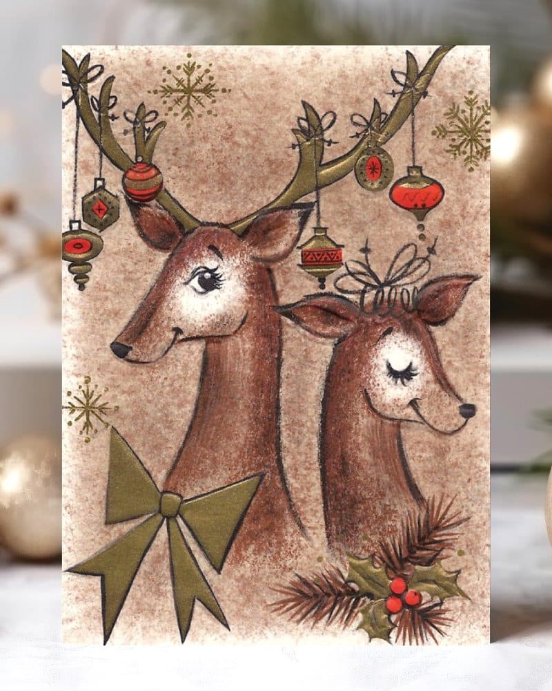 Christmas card illustration of two reindeer adorned with ornaments and a bow.