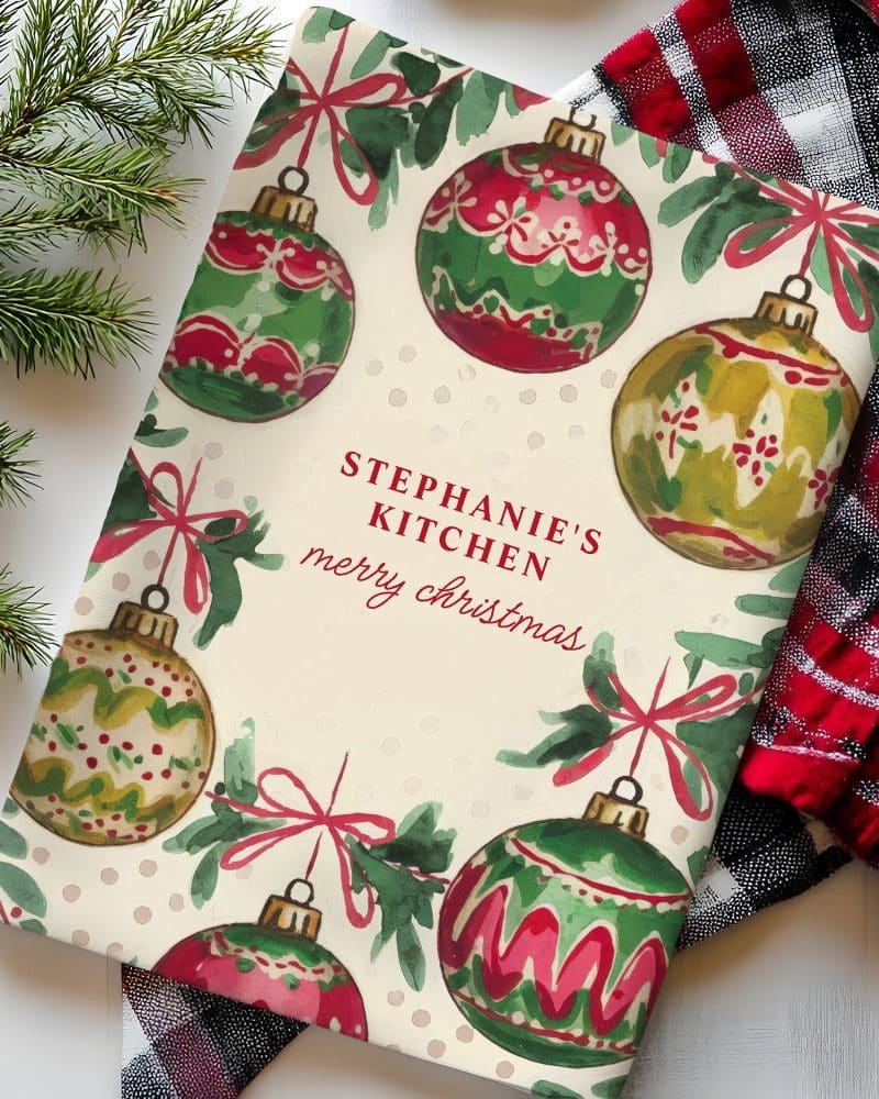 Personalized Christmas kitchen towel with illustrated ornaments.