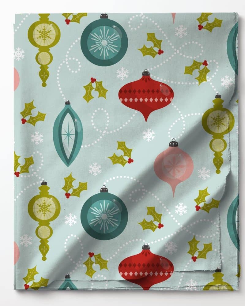 Light blue fabric with a repeating pattern of vintage Christmas ornaments and holly.