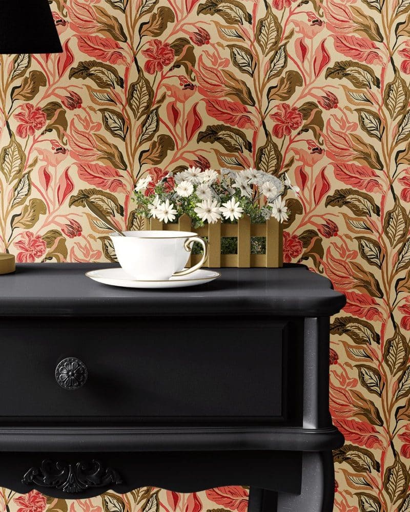 A teacup and saucer sit on a black nightstand against a floral wallpaper.