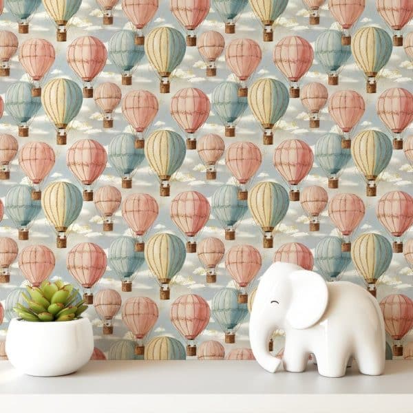 Pastel-Colored Hot Air Balloons On A Light Blue Background, With A Small White Elephant Figurine In The Foreground.