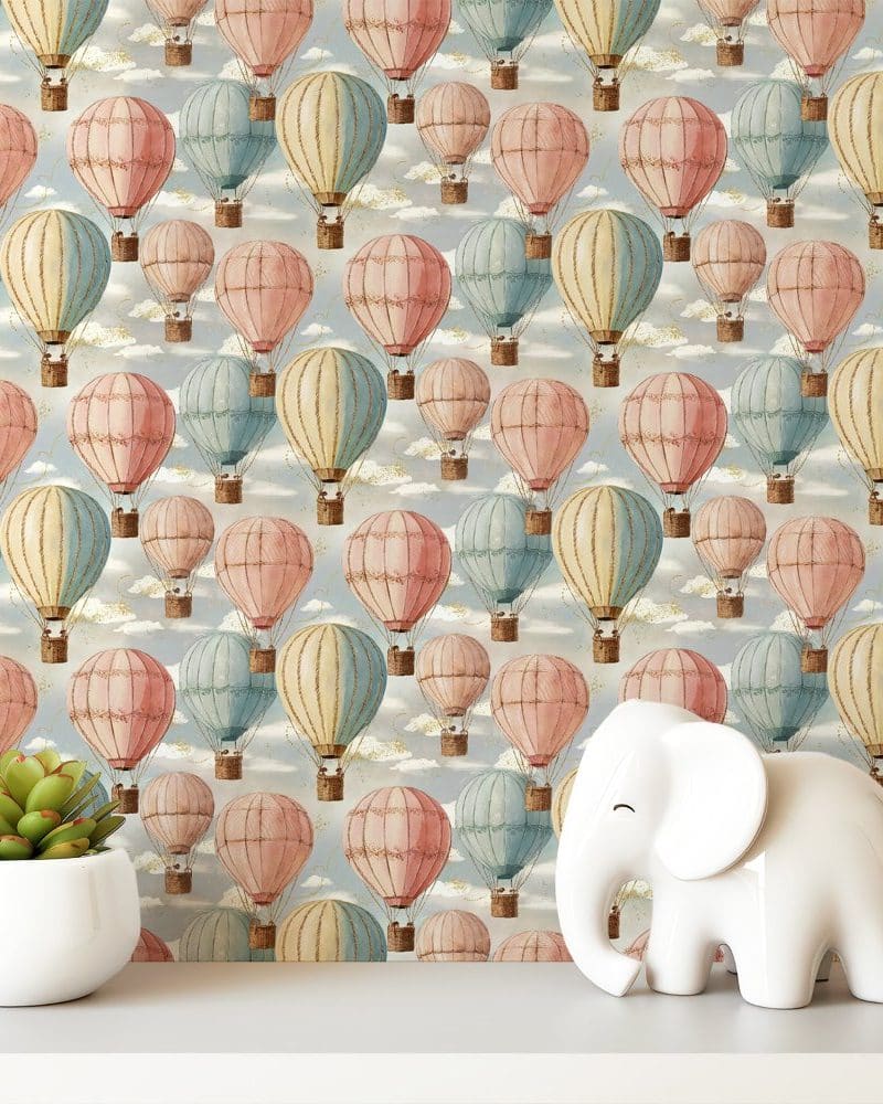 Pastel-colored hot air balloons on a light blue background, with a small white elephant figurine in the foreground.